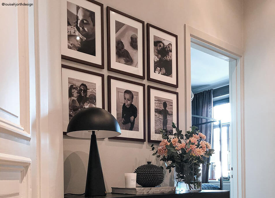 Fotófal az előszobában, fekete-fehér képek sötétfa keretben